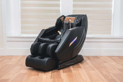 Black massage chair on a wooden floor with white walls and windows in the background