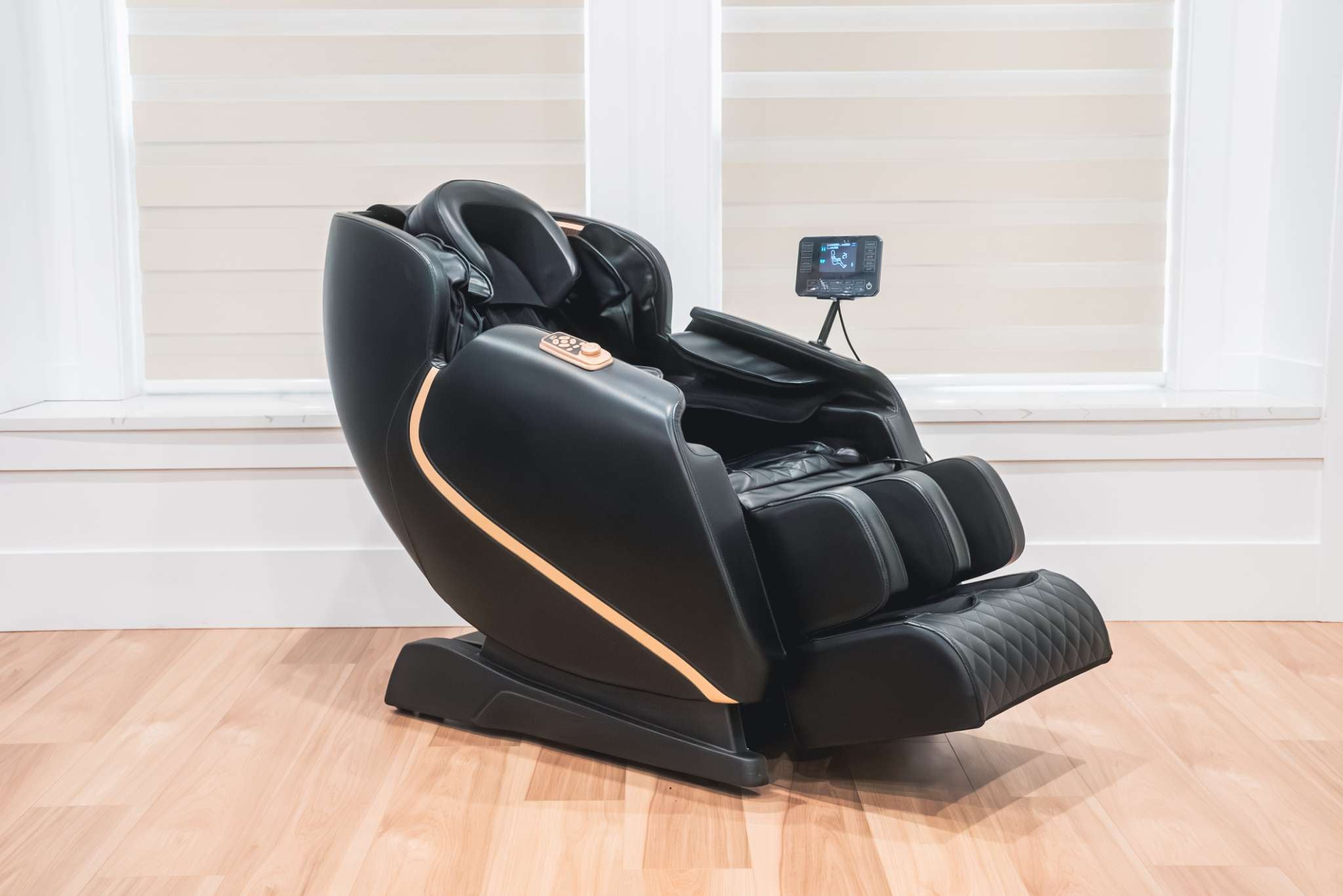 Black massage chair with screen on a wooden floor